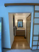 Before: The design team kept the layout for the bathroom, with a walk-in closet to the left, and a shower/toilet room to the right. They swapped out a swing door for a pocket door.