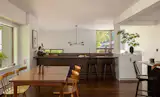 The team added about 350 square feet to the lower level, via a sunken living room that's at grade with the backyard. There's now a built-in desk for the children where the back wall used to be, cabinet storage, and stairs down to the living room.
