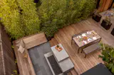 The 1x6 Ipe decking is from Crosscut Lumber, and delineates the dining area from the lounge area. Concrete pavers from Mutual Materials mark the lounge area, also with a built-in bench and concrete fireplace.
