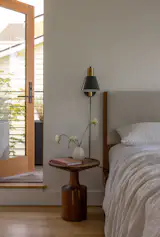Wittman added a small private deck for the parents off their bedroom. A Modern Bed by West Elm, is joined by the Cylinder Task Wall Light by Rejuvenation, and a Turn Tall Side Table in Wood by Blu Dot.