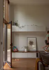 The mudroom cabinets blend into the wall color and the walnut top doubles as a bench.