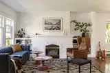 The living room was kept as is, with the existing painted woodwork and fireplace. The dark wood floors inspired the walnut detailing in the new addition.