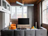 In the living room, Roth combined the Perron Pillo Sectional by DWR with a Verner Panton for Verpan Easy Chair, by Danish Design Shop. The sound absorbing chandelier is the Acoustic Static Links by LightArt. The full-length drapery, custom by Blinds Couture, help with sound absorption and cozy up the space.