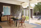The dining room now sits where the living room used to be. It has a Le Corbusier LC6 dining table and vintage chairs, as well as a DWR credenza and custom art.