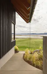 Outdoor, Back Yard, Side Yard, Trees, Shrubs, Gardens, Grass, Walkways, and Hardscapes Hale specified deep eaves in order to protect the house from the site’s strong winds, which sometimes hit 50 miles an hour coming off the water.