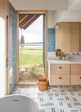 Bath Room, Engineered Quartz Counter, Cement Tile Floor, Undermount Sink, Freestanding Tub, Wall Lighting, Accent Lighting, Soaking Tub, Full Shower, and Ceramic Tile Wall The primary bathroom has Concrete Collaborative’s Way Cooler tile on the floor, and two-by-eight-inch Fireclay tile in Caribbean on the walls. The custom vanity is made of alder with a Caesarstone counter.