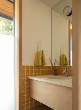 Bath Room, Engineered Quartz Counter, Undermount Sink, Wall Lighting, Accent Lighting, and Ceramic Tile Wall The powder bathroom walls feature three-by-three-inch Fireclay tile in Sunflower.