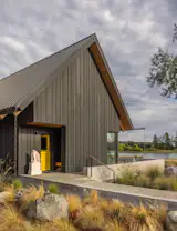 Exterior, House Building Type, Farmhouse Building Type, Metal Roof Material, Wood Siding Material, and Gable RoofLine SHED Architecture + Design helped the owners of this two-acre property in Silverdale, Washington, develop a master plan. It involved remodeling the existing 1930s brick house into a two-bedroom guest house for their adult children, then building a second home for themselves (and more guests). A mudroom with a yellow Dutch door faces the brick house, as well as a walkway linking the two residences.
