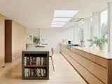 The kitchen was the most important room for the couple, who love to cook and spend a lot of time in the room. In the budget, they prioritized custom cabinetry and a sixteen-foot-long custom concrete island by Cement Elegance. Helland Architecture added large picture windows to overlook the yard.