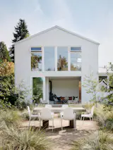 The remodel included a second-story addition of a primary suite, above the garage, and a new sunken sunroom that opens to the yard. Connie designed the outdoor dining area to line up with the opening in the sunroom, for sightlines and easy access between it and the kitchen.