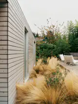 On the 641-square-foot ADU and pool house, a continuous cedar plank rainscreen wraps walls and roof, at a cost of about $40,000, with windows outlined in aluminum.