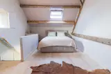 In the loft, complete with operable skylight, the wood ceiling is painted "Magnolia