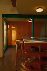 Granite counters cover the cabinets, and the island's open shelves were inspired by the work of Donald Judd. Tiled toe kicks, with tile from the Rairies Montrieux factory, gives them the appearance of floating against the wall.