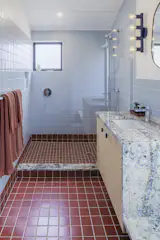 Bath Room, Undermount Sink, Stone Counter, Full Shower, Ceramic Tile Floor, Open Shower, Ceiling Lighting, Wall Lighting, Recessed Lighting, Accent Lighting, and Ceramic Tile Wall There is Fireclay Natural Press tile in Carmine with a satin sheen, on the floor, and Fireclay Natural Press Tile in Egyptian Blue, also in a satin sheen, on the walls. The Color Vogue sconce in cobalt is by Dutton Brown, and the sink has a Kohler Parallel faucet in chrome.