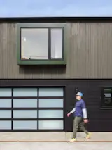 Garage, Garage Conversion Room Type, Detached Garage Room Type, and Storage Room Type The lower level has an Elegant EL100 aluminum and glass garage door and horizontal siding painted the same color as the main house. The upper level has vertical siding with a bay window wrapped in forest-green metal.