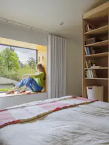 Windows and Picture Window Type The bay window is the sunniest spot in the apartment, and it provides a view out from the bed. The Eduard Pivot sconce in Shell White is by Schoolhouse.