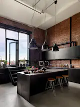The counter space was tripled, thanks to an island with oxidized Dekton installed in a waterfall treatment. The stairs were widened to become seats. "You can sit down there with a glass of wine,