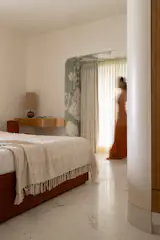 Custom storage curves at the entry to the room, with an arched alcove lined in marble.