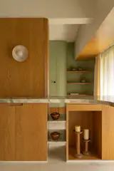 Custom storage everywhere allows the couple to keep the home clutter free. The wall lights in the living room are by Geo Lighting.