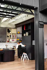 Custom blackened steel panels from Upper Story Design cover the refrigerator.