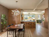 In the dining room, Mackenzie combined Linnea Charcoal wallpaper from Sandberg with a Gingko Plume Chandelier by Vakkerlight and a table and chairs from Sobu Oakland.