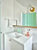 The Q sconce from Misewell is mounted on the mirror. "I wanted as much light bounced around in there to make the room feel as big as possible and I think mirrors are such a great way to do that,