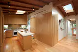 White oak wraps the corner. Integrated doors demark a coat closet, laundry and pantry. The counters are Taj Mahal Quartzite and the tile is from Equipe Ceramics. "We looked for a tile that had a glaze where you can see the process and the way the materiality comes through,