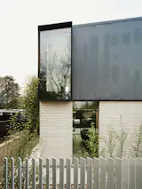 The upper window brings light into the interior staircase, and the lower window allows Kiki to see into the front yard from her desk.