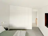The built-in storage in the bedroom follows the line of the ceiling.