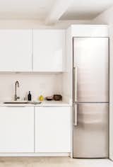 A built-in Liebherr refrigerator pairs well with the bright white cabinets and concrete floors.