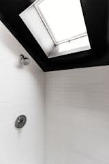 A skylight brings in natural light and creates the feeling of a higher ceiling in the shower.