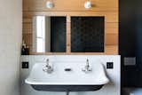 The new wall mounted sink matches the tub style and a half-height wall creates a functional ledge.