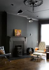 Living Room, Chair, Ceiling Lighting, Floor Lighting, and Medium Hardwood Floor The second floor living room has a large south facing bay window that spills natural light deep into the home. In this room, all walls and trim were painted dark gray and new wood floors are stained in a medium tone.  Photo 4 of 17 in Mission Mood by SF Design Build