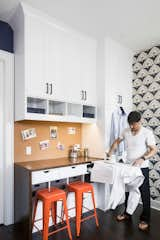 By removing the bi-fold closet in the office we were able to create space for her craft area: a counter height custom millwork piece with basket bins, perfectly sized openings for assorted craft papers, ironing board drawer, cork board, concealed printer, and even Halloween costumes.