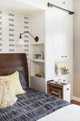 Optimum functionality was important for the bedside built-ins. Clients each a pull out nightstand with adjustable shelves and wood top, open shelves facing the bedside, and articulating sconce with it's own switch. The overall aesthetic is warm, clean and minimal, with white cabinets, stained European white oak floors, and matte black hardware. An accent wall of Cavern Home wallpaper adds interest and ties the finishes of the room together. 
