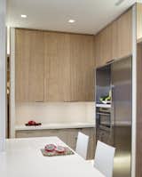 Engineered Quartz Counter, Vinyl Floor, Wood Cabinet, White Cabinet, Laminate Cabinet, Metal Cabinet, Ceiling Lighting, Dishwasher, Undermount Sink, Refrigerator, Wine Cooler, and Kitchen Kitchen: Corner View  Photo 4 of 5 in State-of-the-Art Central Park Kitchen, NY by Lilian H. Weinreich AIA