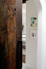 A large handmade (by the owner) rustic barn door divides the room (and shows off a pretty arched door opening) from the rest of the house.