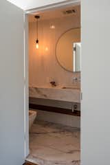 powder bath, marble sink and foor, floating shelf, round mirror