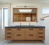 The main bathroom is a study in restraint. A concrete ramp sink sits on a vertical grain oak from Querkus.