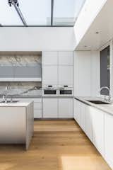 Kitchen, Concrete Counter, White Cabinet, Light Hardwood Floor, Marble Backsplashe, Ceiling Lighting, Recessed Lighting, Wall Oven, Microwave, and Undermount Sink  Photo 6 of 6 in Kitchen Ideas by Jim Malcolm from Spruce