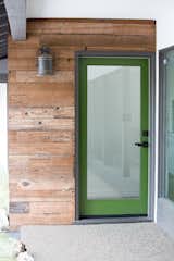 A grass green front door draws from the verdant foliage blanketing the 38,000 sq. ft. hillside property. Its earthy tone complements the rich warmth of reclaimed fence wood that finds new life as siding.