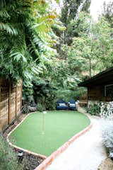 Instead of a traditional front yard, a playful putting green welcomes guests at the entry gate.