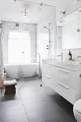 A double vanity is perfect for this busy family and the full width mirror visually expands the narrow space. Heated porcelain floors keep feet warm in the colder months.