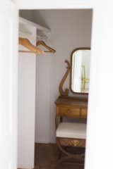 walk-in closet in master bedroom with heirloom vanity and bench