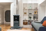 Living Room, Light Hardwood Floor, Shelves, Wood Burning Fireplace, and Sofa An original 1920's restored Goodin Woodburning Stove anchors the cozy living space.  Photo 5 of 9 in Londoners Can Live in This Scandinavian-Inspired, Converted Barge For $424K