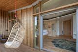Small Patio, Porch, Deck, Wood Patio, Porch, Deck, Bedroom, Bed, Light Hardwood Floor, Pendant Lighting, Rug Floor, and Shelves  Photo 6 of 10 in Les Echasses by Dwell from Harmonizing With Nature, These Eco-Huts Offer Respite in the Heart of France