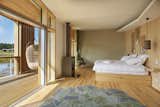 Bedroom, Bed, Chair, Pendant Lighting, Light Hardwood Floor, Rug Floor, and Shelves  Photo 7 of 10 in Harmonizing With Nature, These Eco-Huts Offer Respite in the Heart of France