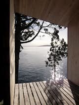 Views are framed to the lake beyond from the covered terrace.  Photo 5 of 9 in A Timber-Clad Sauna in Chile Angles For Lakeside Views