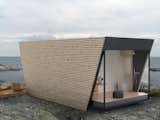 Wood Siding Material, Outdoor, Boulders, Small Patio, Porch, Deck, and Wood Patio, Porch, Deck  Photo 3 of 9 in This Modular Eco-Hotel Room Is Poised to Drop Into Nearly Any Setting