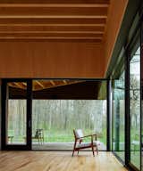 Living Room, Chair, and Light Hardwood Floor Large windows connect the interior to the exterior elements and blend inside to outside.  Photo 6 of 12 in A Dramatic Cantilevered Roof Creates a Spacious Terrace Overlooking Lake Michigan